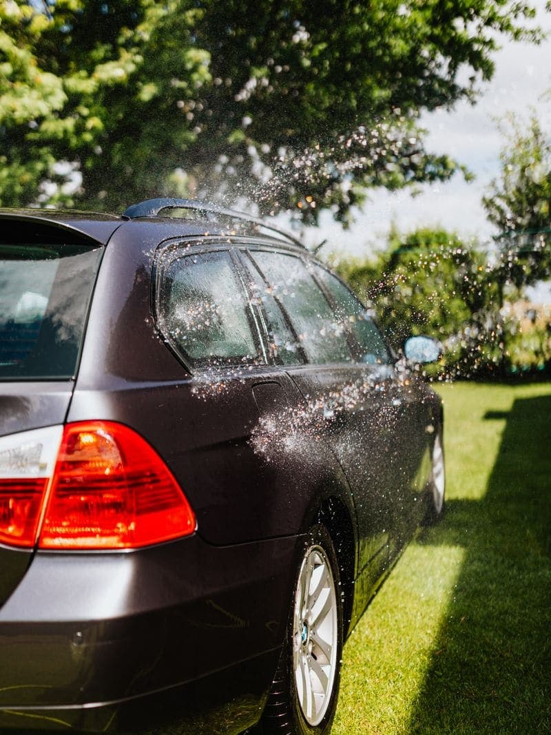 Carro negro recibiendo agua durante el enjuague