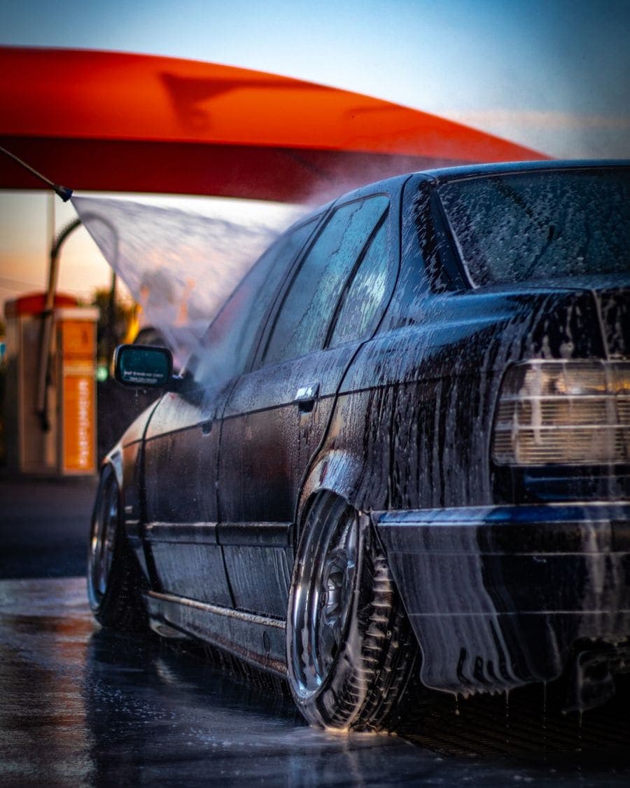 Carro recibiendo agua a presión en una estación de lavado